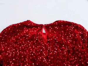 Detail of red sequin dress featuring a keyhole back design and round button closure