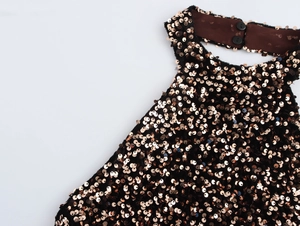 Detail of rose gold sequins on black velvet halter neckline with dual button closure