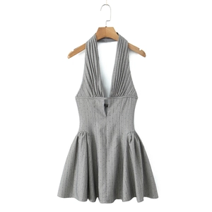 Detail des grauen Halter-Minikleides mit tiefem V-Ausschnitt und radialem Plissee-Design
