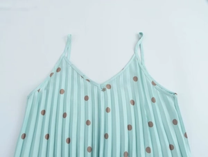 Détail du haut plissé bleu menthe à pois avec col en V et petite fleur argentée