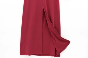 Vue macro détaillée de l'ourlet de la robe rouge foncé avec fente et coutures de qualité