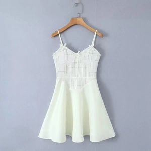 Détail d'une robe trapèze blanche avec nœuds décoratifs et corsage texturé sur cintre