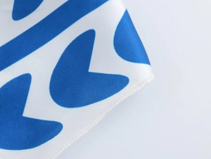 Dettaglio dell'abito con stampa a cuori blu che mostra cuciture precise e tessuto liscio