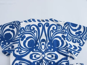 Close-up of V-neckline with baroque blue and white porcelain print and metal button