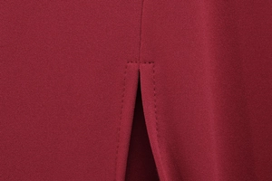Détail macro de la robe en tricot bordeaux montrant la conception de la fente et la couture