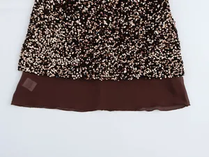 Close-up of rose gold sequins on a backless halter dress with a chiffon hem detail