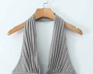 Detailaufnahme des grauen Neckholder-Oberteils mit Polka Dots und Plissee-Struktur
