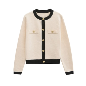 Elegant cream knit cardigan with black contrast trim and decorative gold buttons