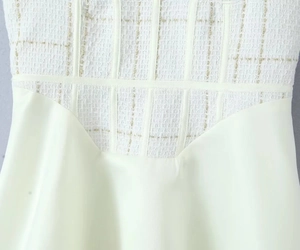 Détail de la taille d'une robe en tweed ivoire avec fils dorés et empiècement en tissu
