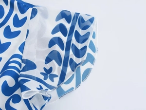 Dettaglio del tessuto in chiffon a fiori blu con cucitura overlock bianca sull'orlo