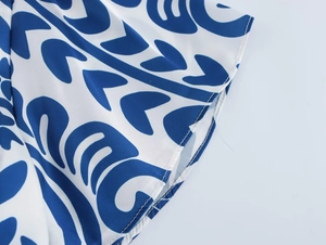 Close-up of blue floral print on white dress with fine double stitching detail