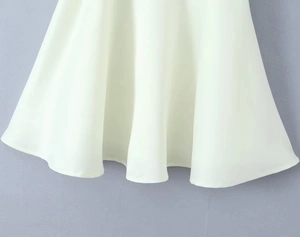 Gros plan détaillé de l'ourlet ondulé et fluide de cette élégante robe blanc cassé chic