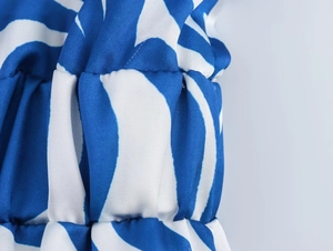 Dettaglio del tessuto con stampa floreale blu e bianca e trama elastica arricciata