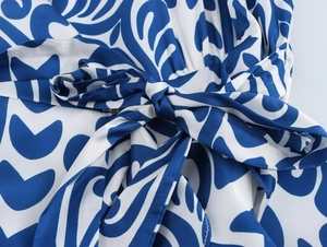 Detail of blue and white leaf print fabric with a waist tie-up bow on long dress