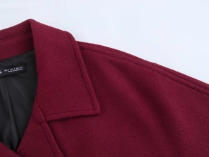 Close-up of double-breasted wool blend coat collar with detailed stitching and size label