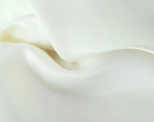 Vue macro détaillée du tissu en soie blanc crème avec un éclat et une texture lisse