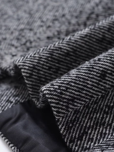 Macro detail of grey herringbone texture and smooth black silk lining of the stylish jacket
