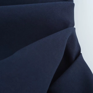 Vue macro du détail de tissu sergé bleu foncé montrant une texture textile de qualité