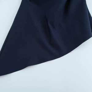Gros plan du haut asymétrique bleu marine montrant les coutures fines et la texture lisse