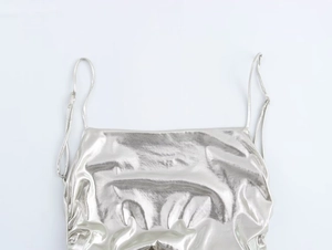 Detailed close-up of metallic silver foil pleated camisole with thin spaghetti straps