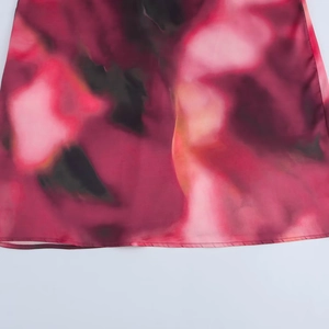 Dettaglio del tessuto in raso con stampa astratta rosa e viola e cuciture di alta qualità