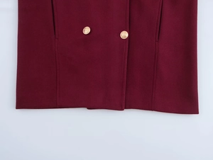 Close-up of wine red wool coat fabric with premium embossed golden buttons