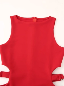 Detalle de un vestido rojo con aberturas en la cintura y cinturón con hebilla metálica
