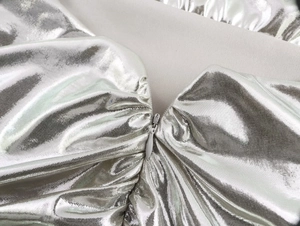 Detailed macro view of the silver metallic pleated fabric and high-quality invisible zipper