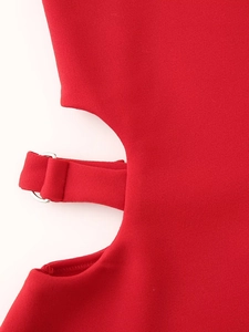 Detalle del vestido rojo con recorte en la cintura, hebilla en D plateada y tela tejida