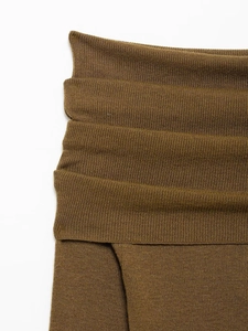 Detail of brown ribbed knit fabric showing soft texture and layered pleated structure
