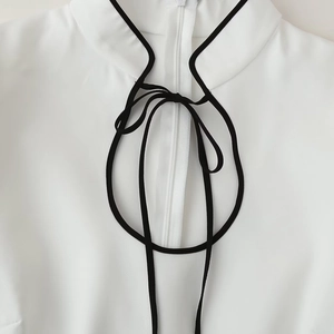 Abito bianco elegante a maniche lunghe con collo a listino e fiocco profilato in nero