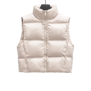 Detailed close-up of a light beige quilted puffer vest with stand-up collar and zipper