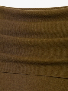 Detailed macro view of the olive green ribbed knit fabric texture and soft material