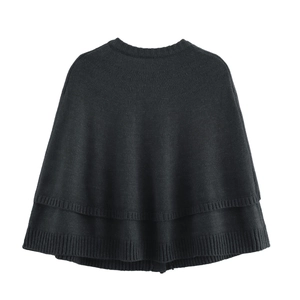 Detail view of the fine knit texture and double-layered hem on this black knitted poncho