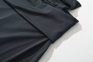 Detail shot of black knitted fabric texture with waistline folds and stitching
