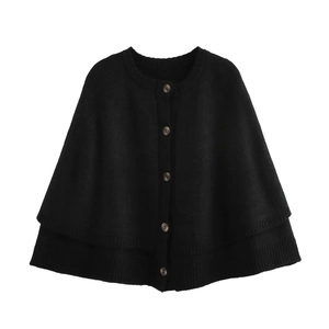 Close-up of black knit capelet featuring tortoiseshell buttons and layered hem detail