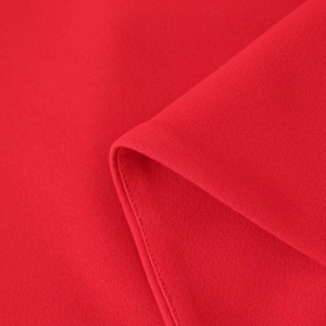 Vista detallada de vestido en tejido rojo con costuras finas y pliegues suaves