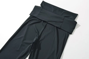 Detail of cross high waist design on black high-stretch slim fit flared trousers