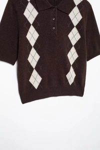 Detail of knitted polo shirt collar with diamond argyle pattern and classic buttons