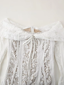 Détail de la dentelle florale blanche et du nœud lacé sur la robe à épaules nues