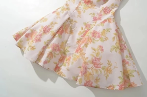 Detailed view of the light pink floral print fabric with elegant pleats and hem draping