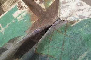 Detail des V-Ausschnitts mit abstraktem Geometrieprint und feinen Nähten auf Webstoff