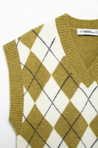 Close-up of diamond pattern knit vest featuring V-neck and mustard yellow textures