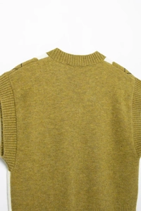 Detail of olive green knit vest with cream shoulder patchwork and ribbed neckline