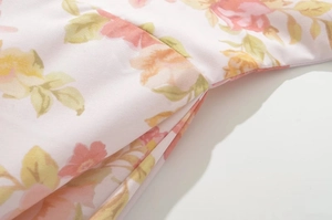 Close-up detail of floral chiffon fabric showing neat stitching and pink flower print