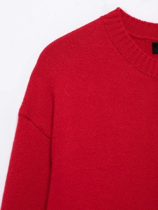 Close-up of the ribbed crew neck and fine knit texture on a red women's sweater