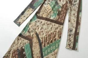 Detail des Vintage-Drucks auf atmungsaktivem Langarm-V-Ausschnitt-Kleid Stoffstruktur