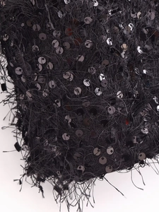 Detailopname van zwarte pailletten en lange franjes op de stijlvolle strapless top