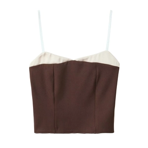 Detail of slim white straps and brown fabric with cream trim on a fitted crop top