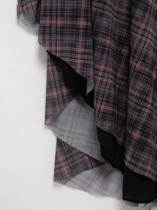 Détail du tissu écossais rouge et noir avec couches de tulle et texture raffinée